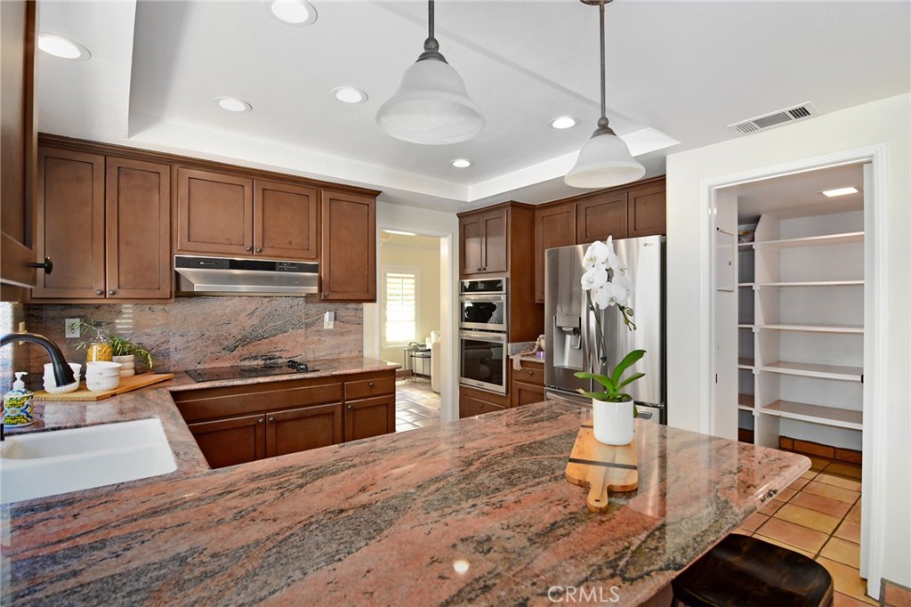 951 Firestone Circle Simi Valley, CA 93065 - Photo 14 of 41 a kitchen with stainless steel appliances granite countertop a refrigerator a stove and a sink with cabinets