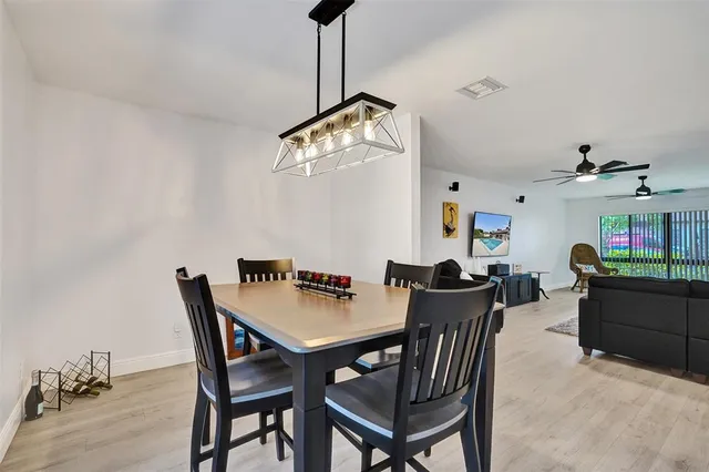 a dining room with furniture a chandelier and wooden floor