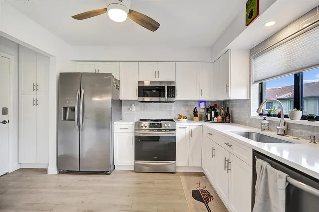 a kitchen with stainless steel appliances a stove microwave and refrigerator