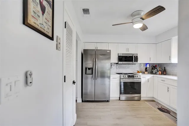 a view of a livingroom with wooden floor and a ceiling fan