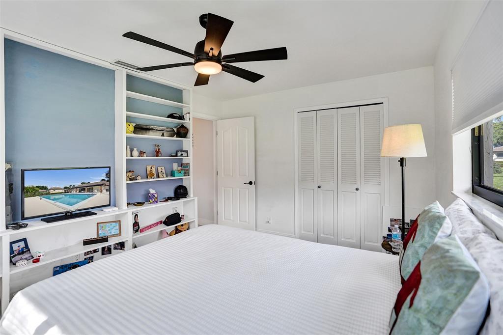 4840 Greentree Lane, Unit B Boynton Beach, FL 33436 - Photo 40 of 68 a bedroom with a bed and a flat tv screen on the dresser