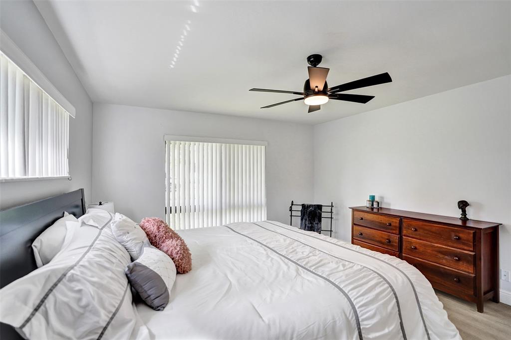 4840 Greentree Lane, Unit B Boynton Beach, FL 33436 - Photo 44 of 68 a bedroom with a bed and a chandelier