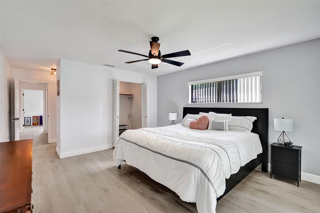 4840 Greentree Lane, Unit B Boynton Beach, FL 33436 - Photo 46 of 68 a bedroom with a large bed and a chandelier