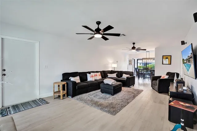a living room with furniture and a ceiling fan