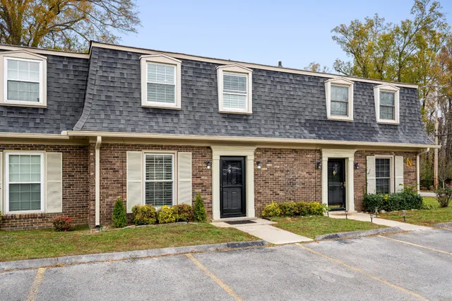 front view of a brick house with a yard
