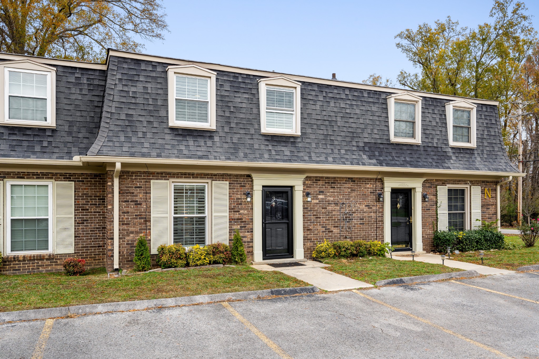 front view of a brick house with a yard