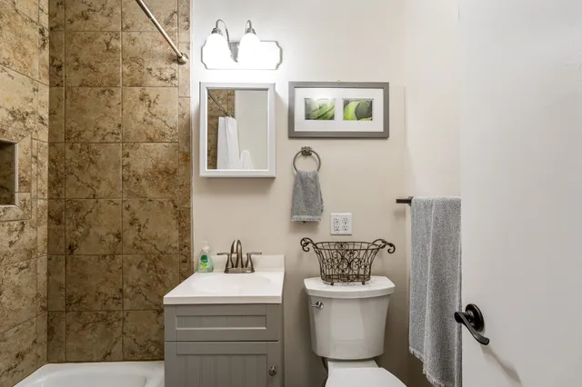 a bathroom with a toilet sink and mirror