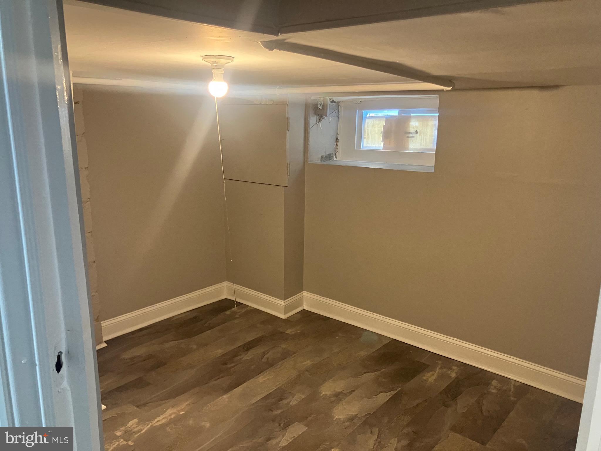 2540 Aisquith Street Baltimore, MD 21218 - Photo 15 of 15 an empty room with wooden floor and windows