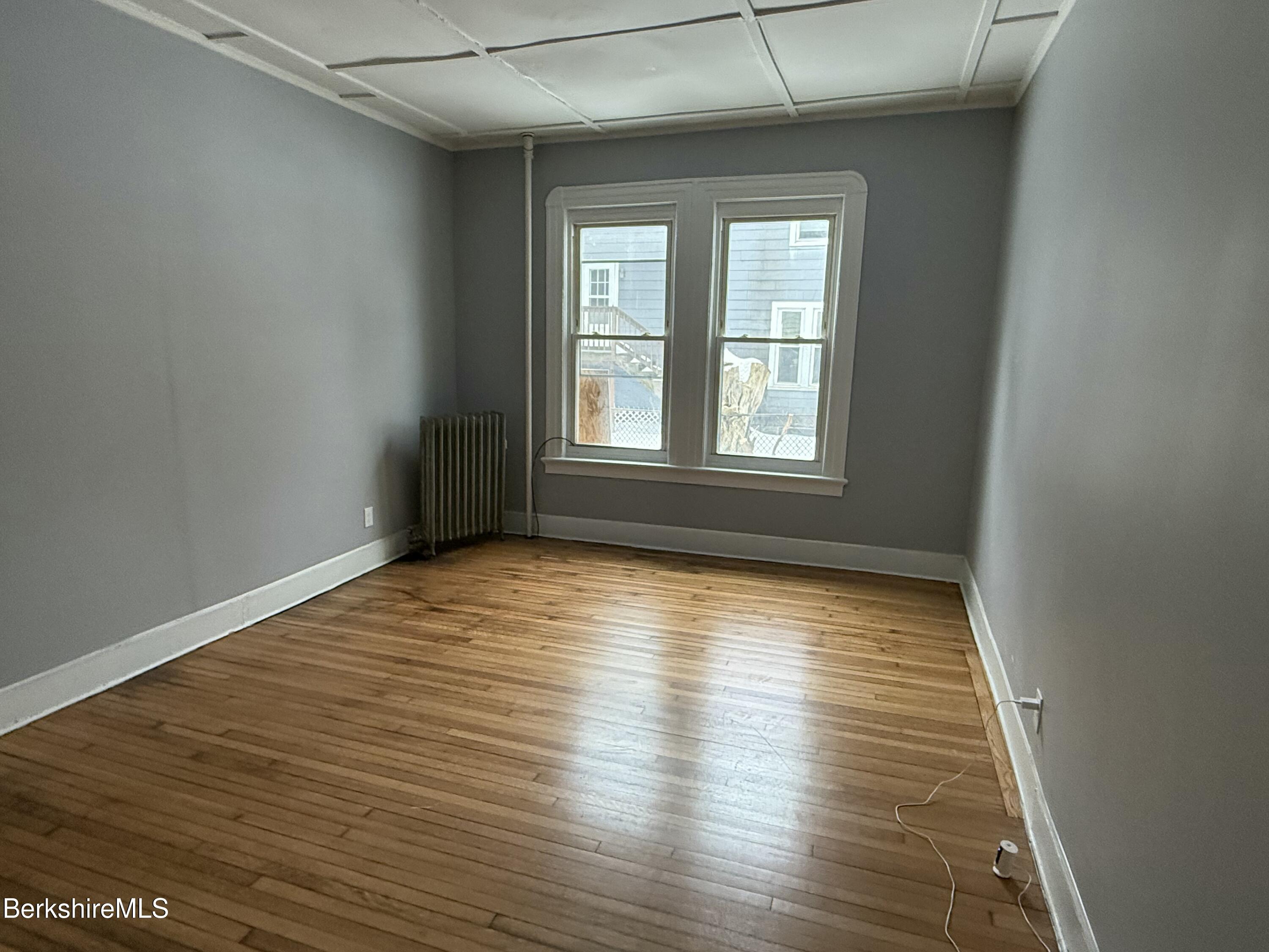 126 Appleton Avenue, Unit 1 Pittsfield, MA 01201 - Photo 1 of 8 an empty room with wooden floor and windows