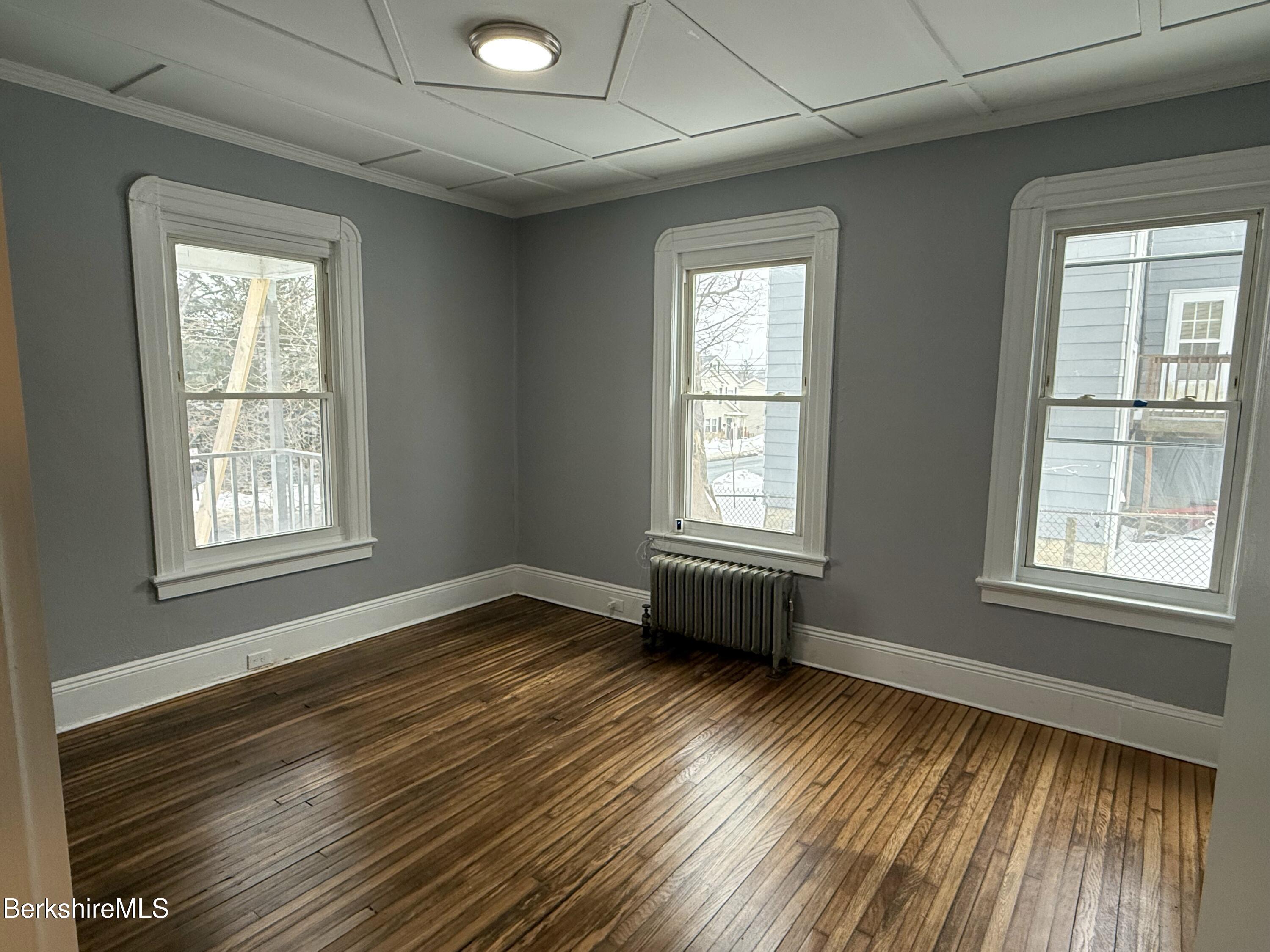 126 Appleton Avenue, Unit 1 Pittsfield, MA 01201 - Photo 3 of 8 a view of an empty room with wooden floor and a window