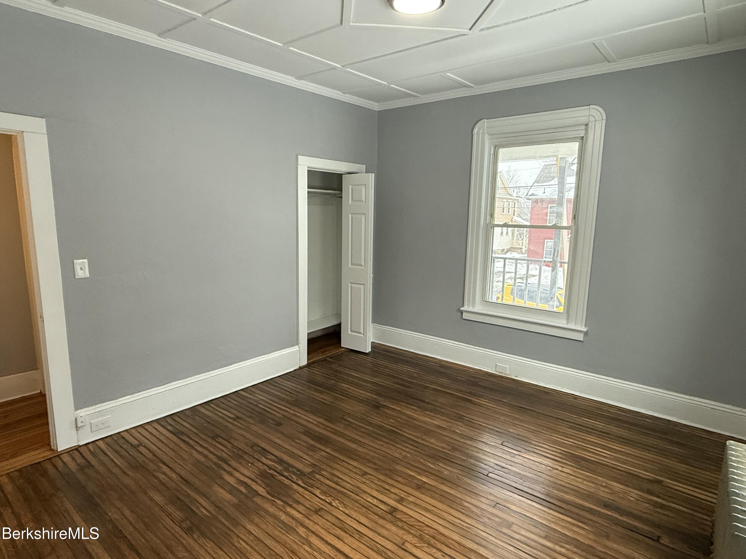 126 Appleton Avenue, Unit 1 Pittsfield, MA 01201 - Photo 4 of 8 an empty room with wooden floor and windows