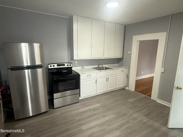 a kitchen with a stove a refrigerator and a sink