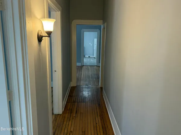 a view of a hallway with wooden floor