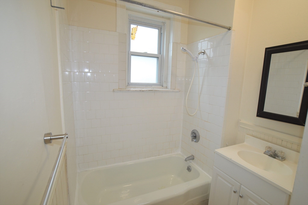 15 Lynde Street, Unit 22 Salem, MA 01970 - Photo 6 of 7 a bathroom with a bathtub sink vanity and mirror