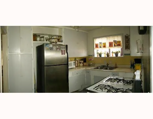 a kitchen with stainless steel appliances kitchen island granite countertop a refrigerator and a stove