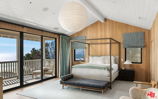 a bedroom with furniture and large window