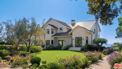 a front view of a house with a yard and mountain view