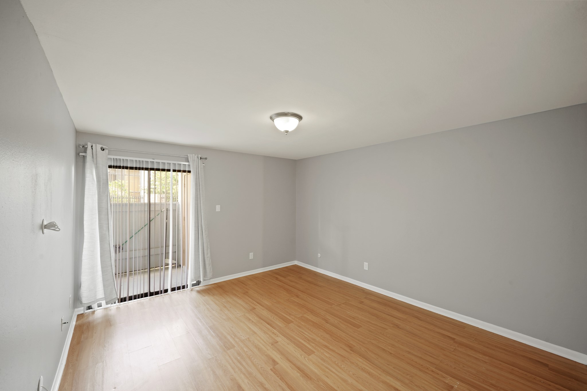 8517 Hearth Drive, Unit 5 Houston, TX 77054 - Photo 11 of 20 a view of an empty room with wooden floor and a window