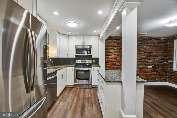 a kitchen with stainless steel appliances a refrigerator sink and stove