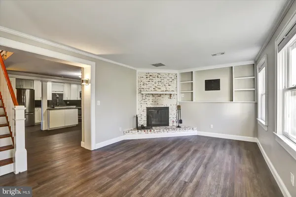 a view of a livingroom with wooden floor and a fireplace