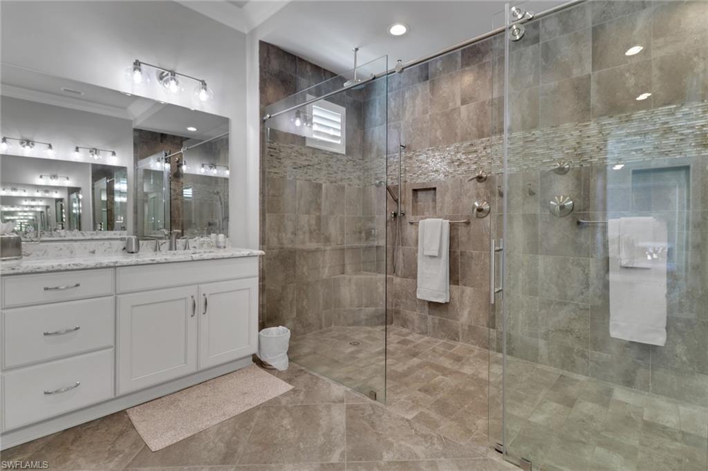 21450 Strada Nuova Circle, Unit A301 Estero, FL 33928 - Photo 12 of 40 a bathroom with a shower a sink and mirror