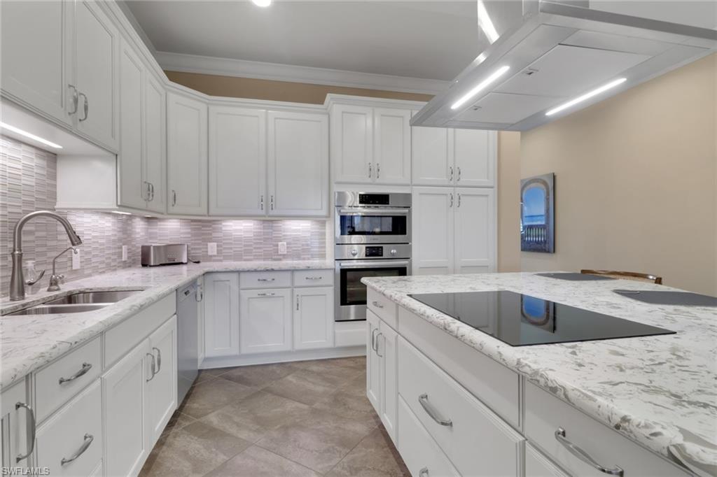 21450 Strada Nuova Circle, Unit A301 Estero, FL 33928 - Photo 3 of 40 a kitchen with granite countertop white cabinets sink and stainless steel appliances