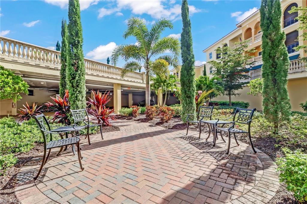 21450 Strada Nuova Circle, Unit A301 Estero, FL 33928 - Photo 40 of 40 a view of a tables and chairs in patio