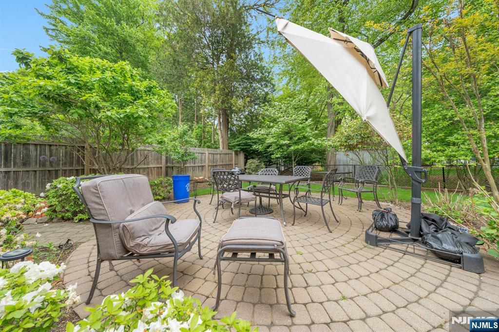 24 Cambridge Road Tenafly, NJ 07670 - Photo 28 of 31 a view of a patio with a dining table and chairs with wooden fence