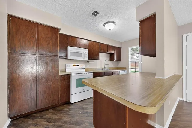 a kitchen with kitchen island a counter top space cabinets and stainless steel appliances