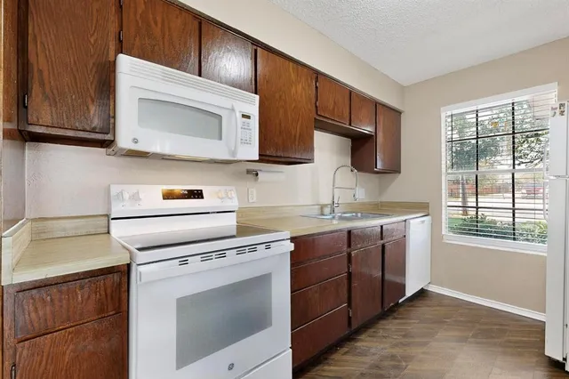 a kitchen with stainless steel appliances granite countertop a sink stove and microwave