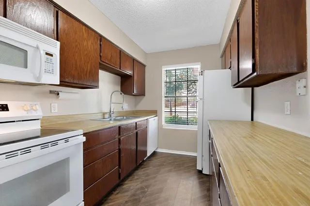 a kitchen with stainless steel appliances granite countertop a sink stove and microwave
