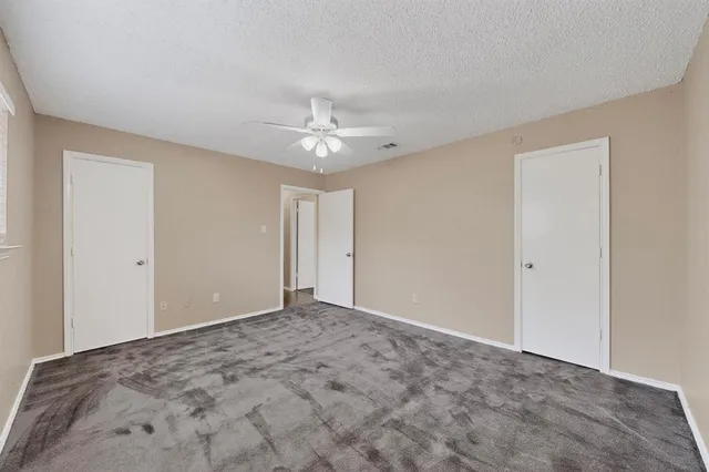 a view of an empty room with a chandelier fan