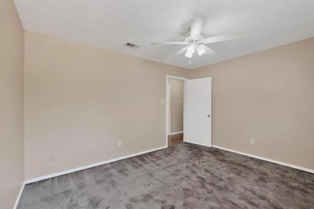 an empty room with a fan and a window