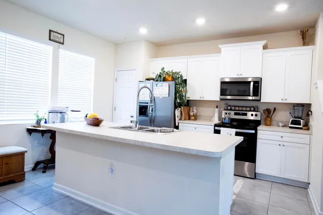 a kitchen with stainless steel appliances a stove refrigerator sink and microwave