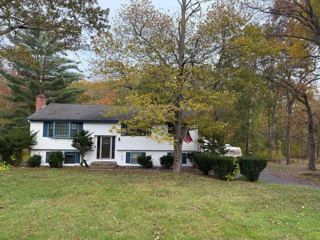 a view of a house with backyard and sitting area