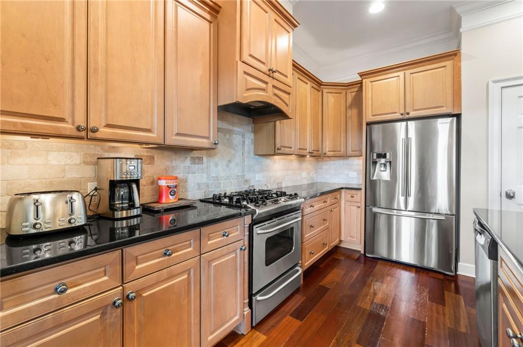 3 Buford Village Way Buford, GA 30518 - Photo 16 of 40 a kitchen with stainless steel appliances granite countertop a refrigerator oven a sink dishwasher and white cabinets with wooden floor