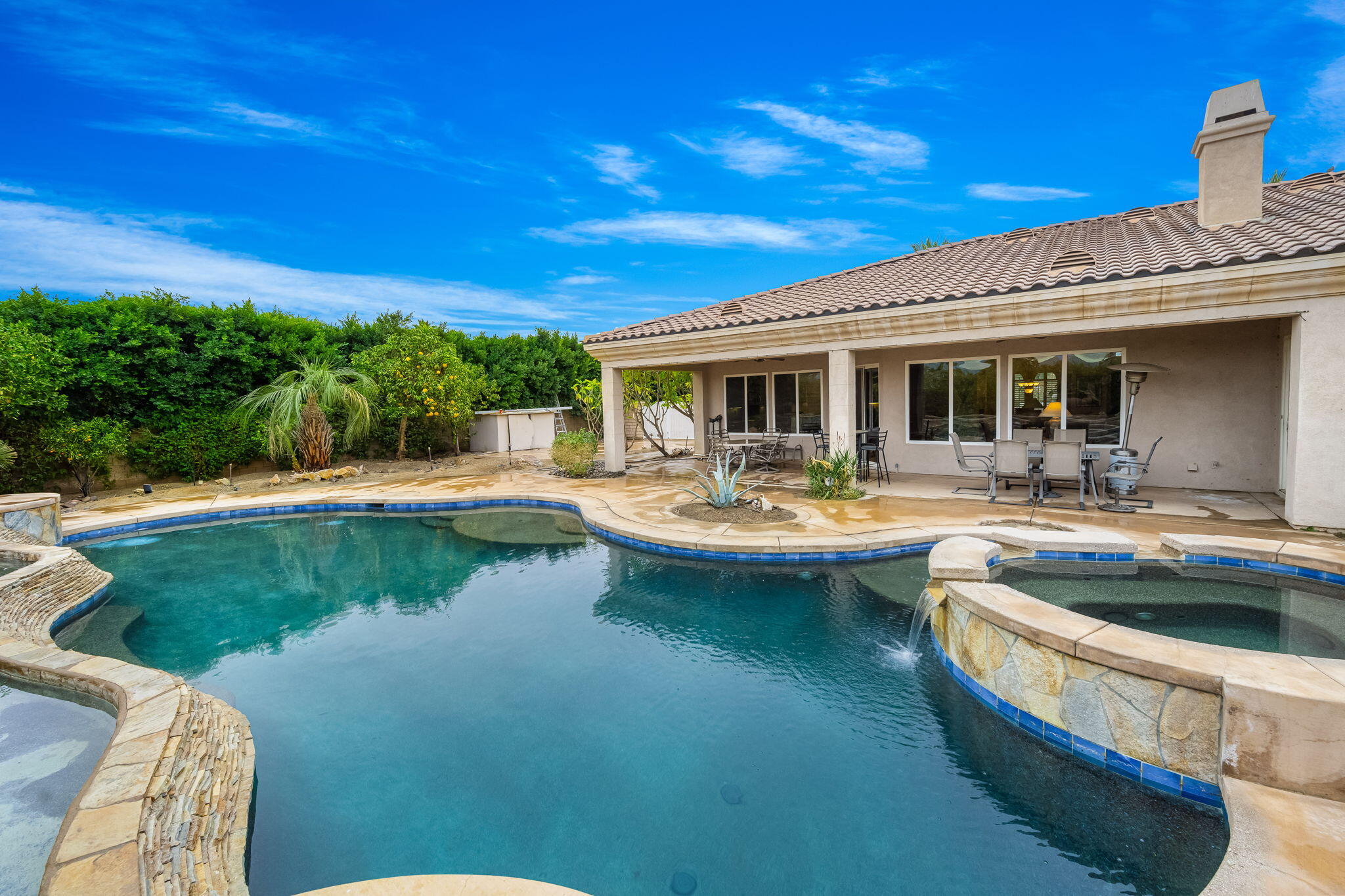 80262 Amazon Indio, CA 92201 - Photo 17 of 45 a view of swimming pool with outdoor seating and house in the background