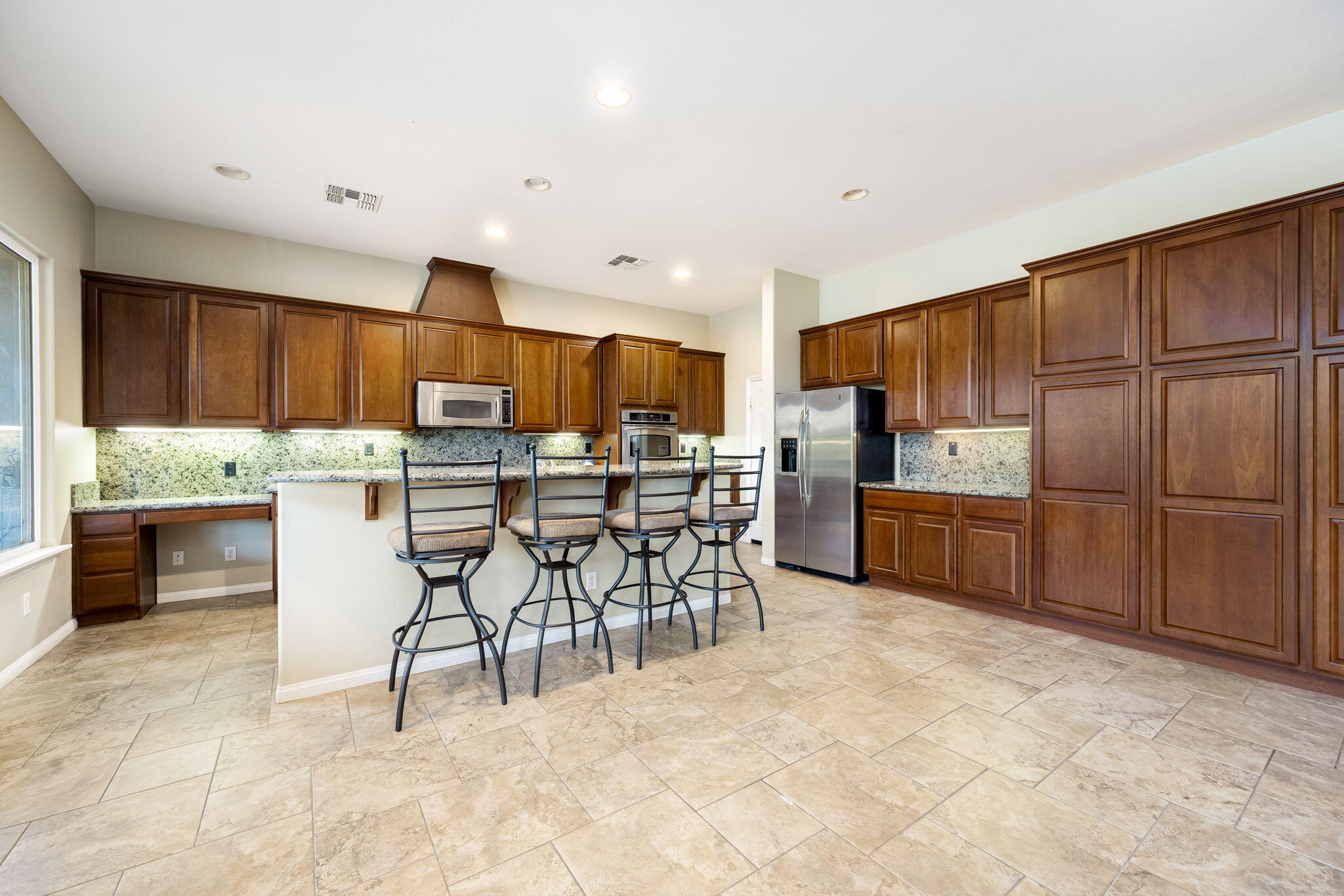 80262 Amazon Indio, CA 92201 - Photo 25 of 45 a kitchen with stainless steel appliances kitchen island granite countertop a refrigerator and cabinets