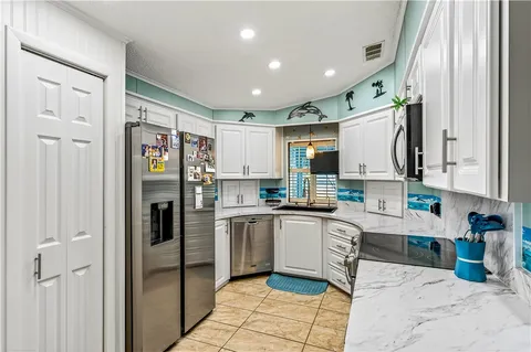 a kitchen with stainless steel appliances granite countertop a refrigerator and a sink