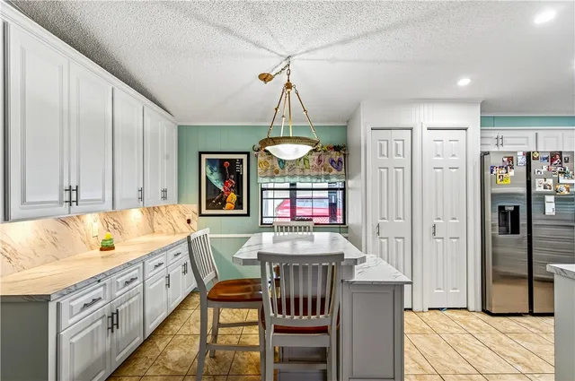 a kitchen with stainless steel appliances granite countertop a refrigerator a stove and a wooden floors