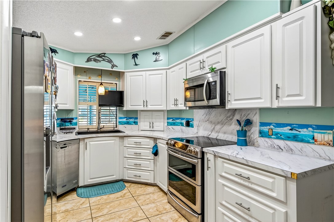 717 Wedelia Drive Sebastian, FL 32976 - Photo 8 of 24 a kitchen with stainless steel appliances granite countertop a stove and a sink