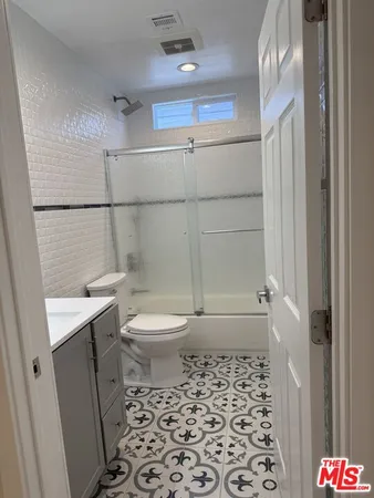 a walk in closet with wooden floor
