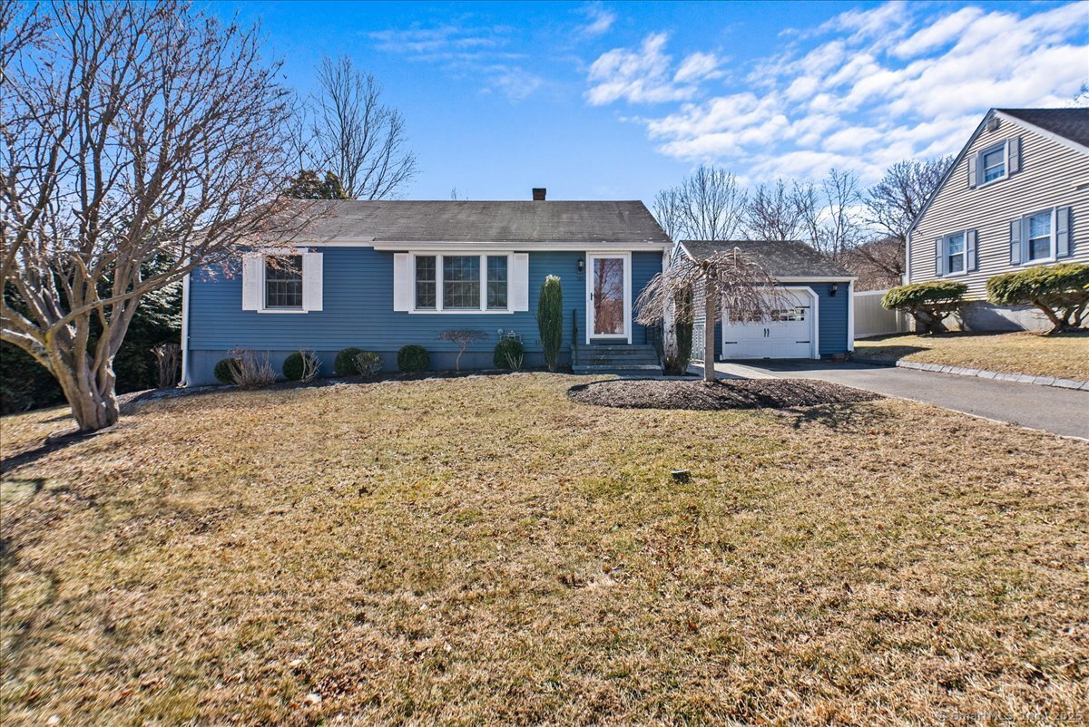 a front view of a house with a yard covered in snow