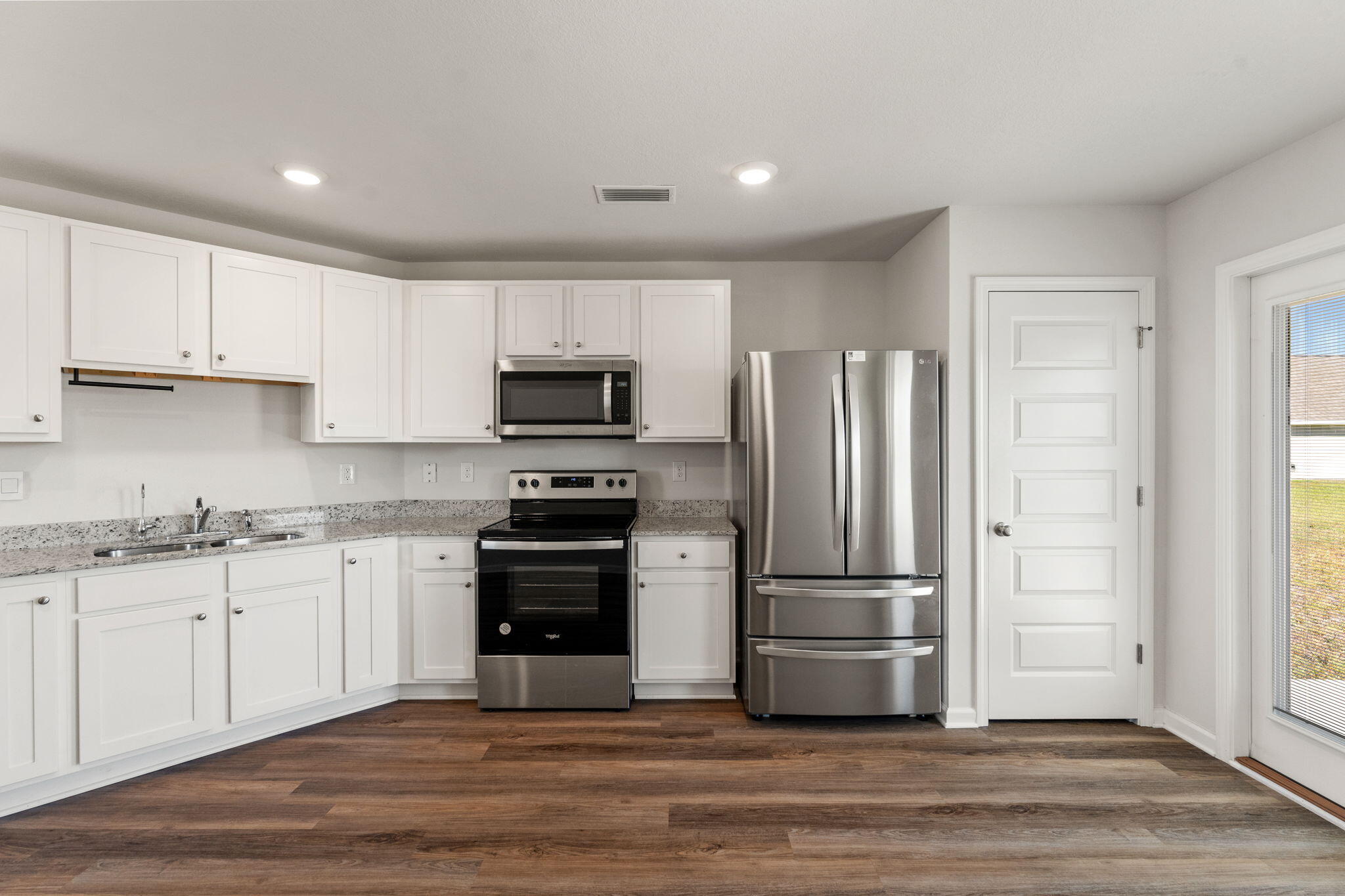 6570 Atkins Road Panama City, FL 32404 - Photo 11 of 50 a kitchen with granite countertop a refrigerator stove and sink
