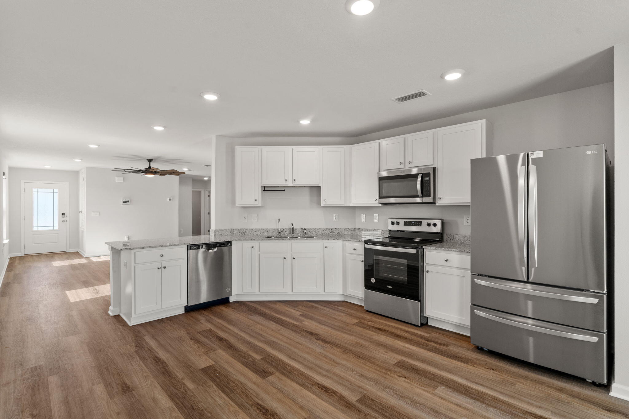 6570 Atkins Road Panama City, FL 32404 - Photo 12 of 50 a kitchen with a refrigerator stove top oven and cabinets