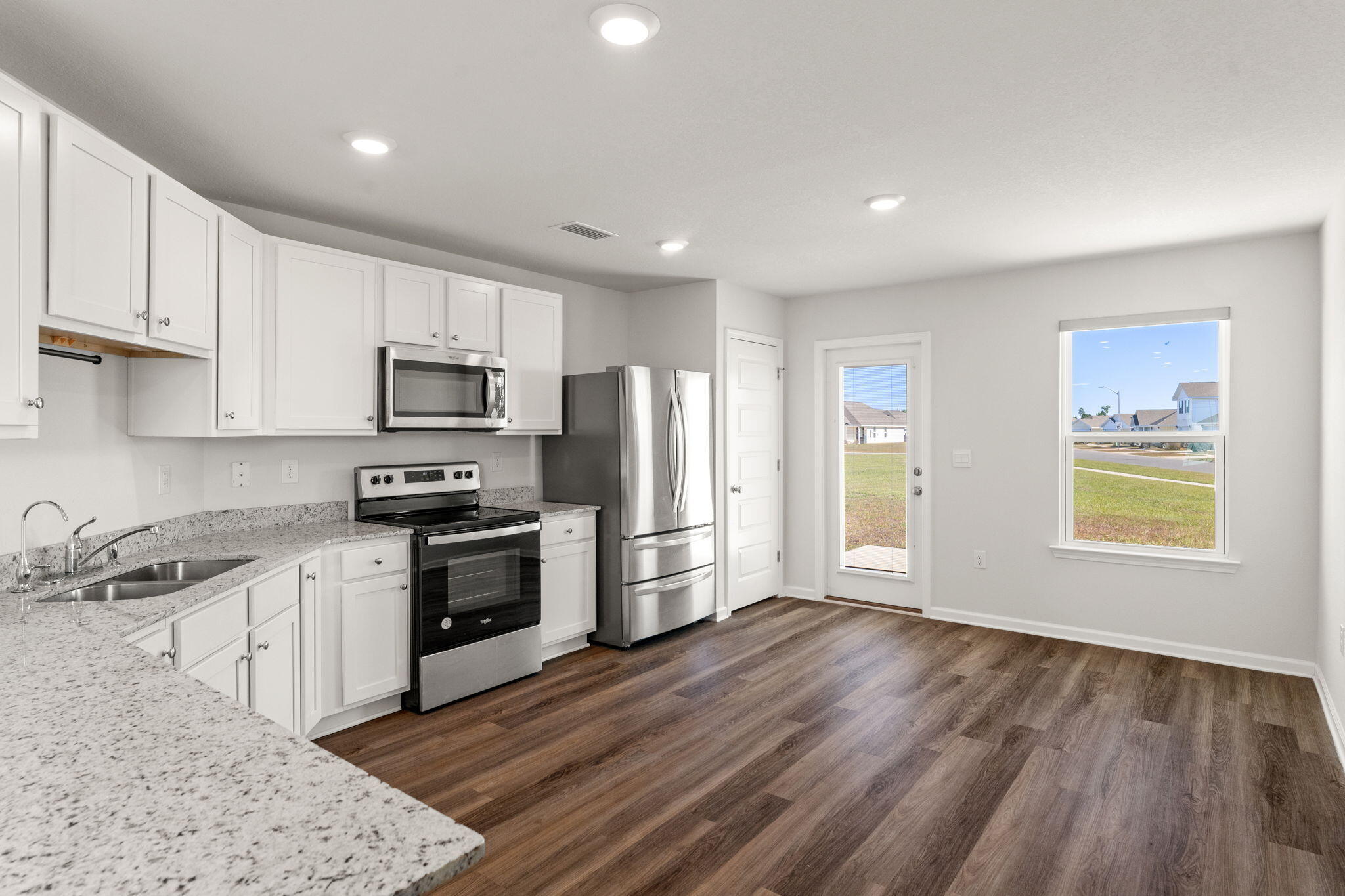 6570 Atkins Road Panama City, FL 32404 - Photo 14 of 50 a kitchen with a sink wooden floor and stainless steel appliances