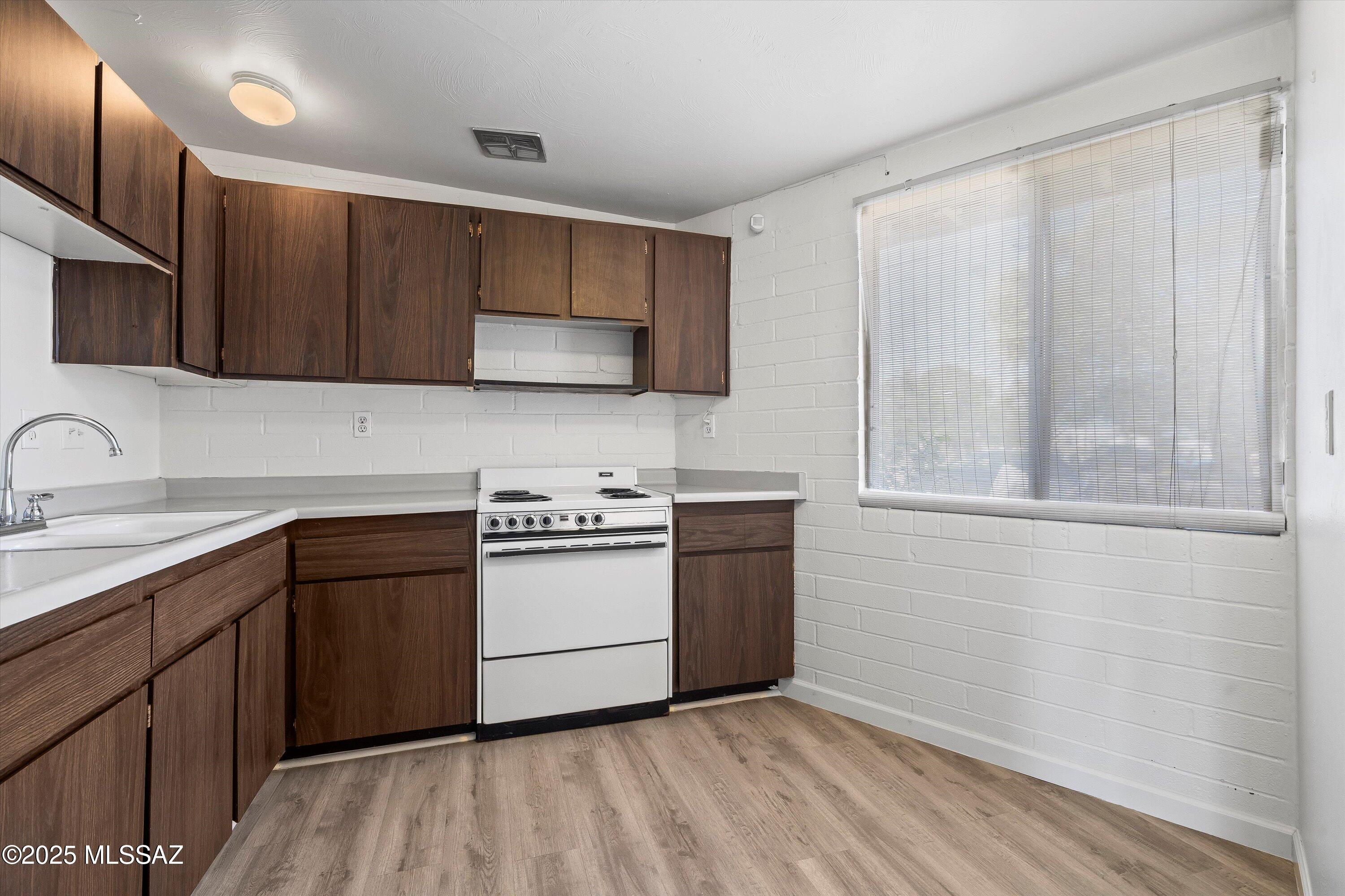 1505 West Roger Road Tucson, AZ 85705 - Photo 6 of 24 a kitchen with a sink and a stove top oven
