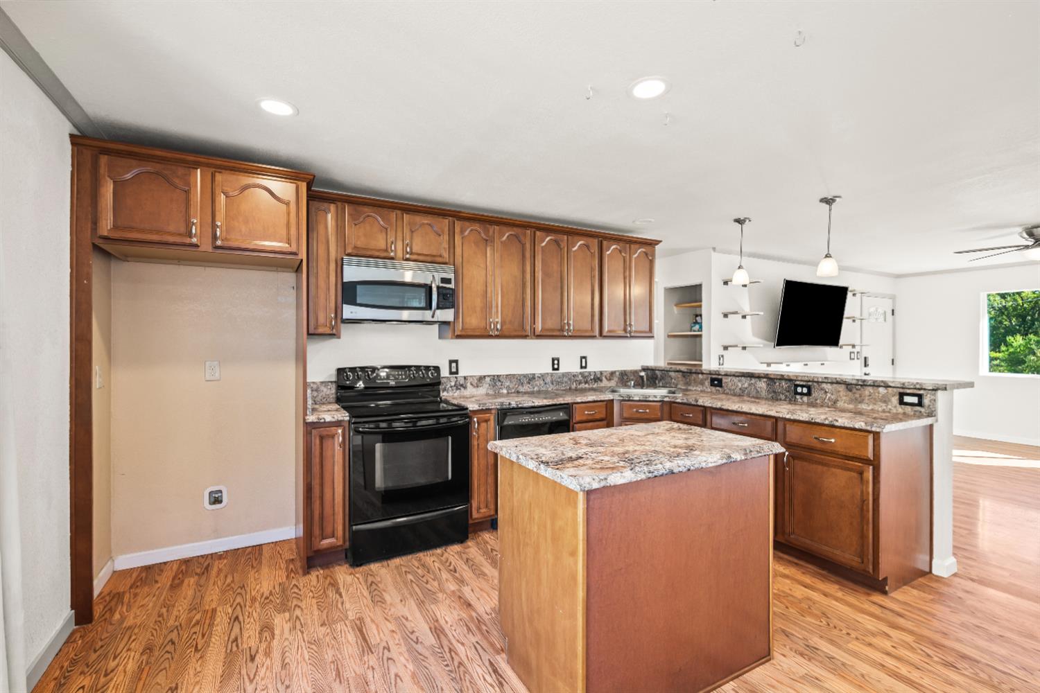 4818 Fall Street El Dorado, CA 95623 - Photo 10 of 31 a kitchen with stainless steel appliances granite countertop a stove top oven a sink dishwasher a refrigerator and a microwave with wooden floor