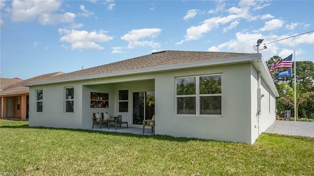 a view of a house with potted plants and a yard