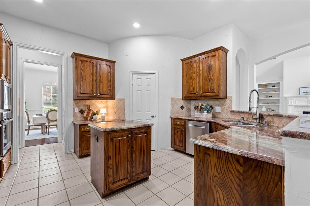 4821 Ravendale Drive Richardson, TX 75082 - Photo 15 of 40 a kitchen with stainless steel appliances granite countertop a stove a sink and a refrigerator